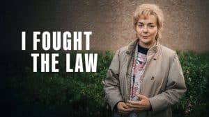 Sheridan Smith as Ann Ming in ITV’s I Fought the Law, standing outside in a beige coat with the series title displayed beside her.